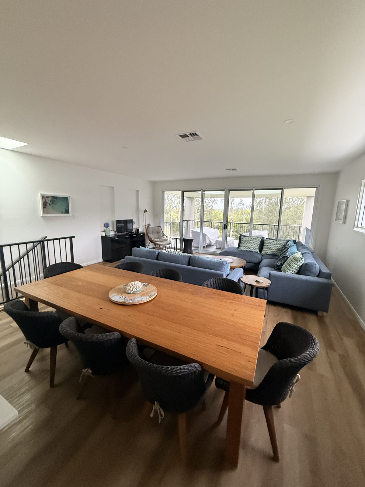 Timber dining table and lounge area at Drift, Tea Gardens